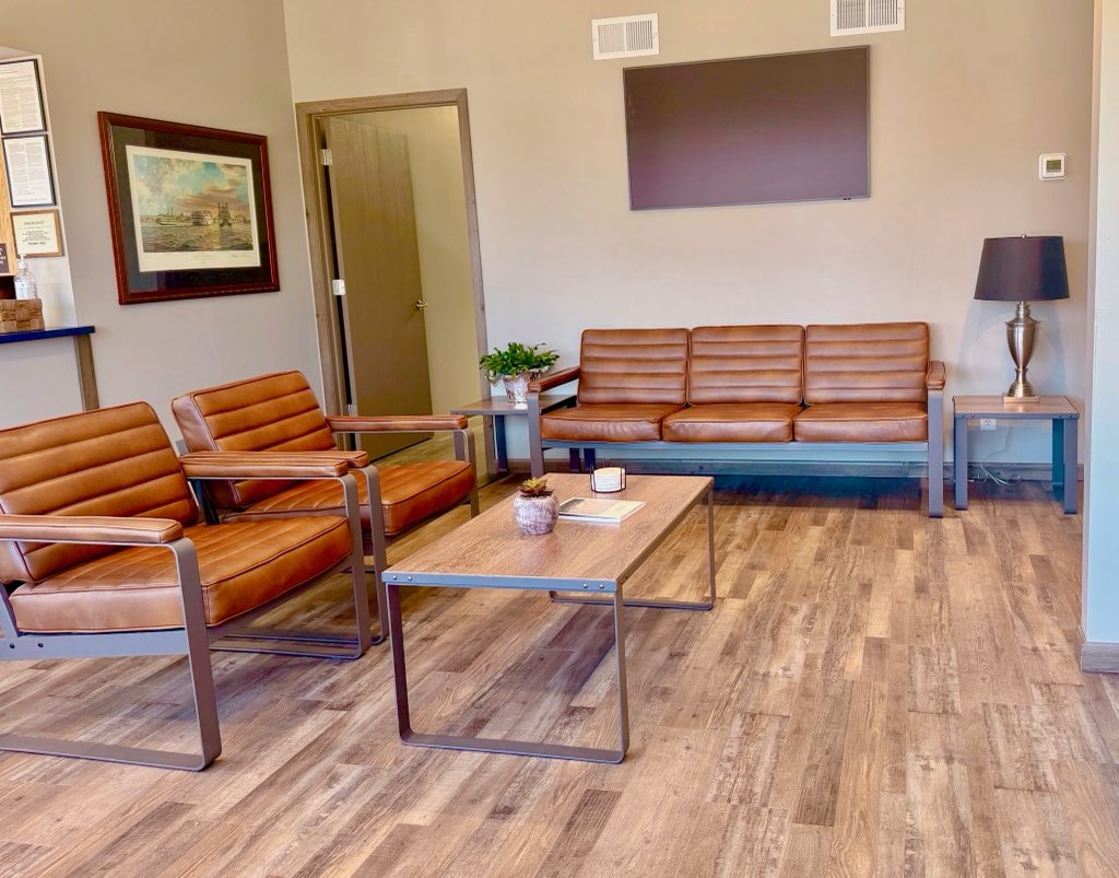 A dental patient opens their mouth with a mirror in front of their lips