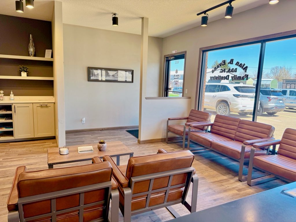 A calendar with Dentist written on the 16th and a pink toothbrush with blue bristles sitting on top