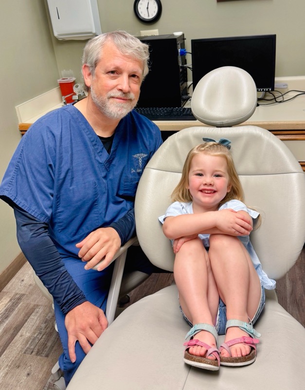 A dentist from Alan B. Evans, DDS, PC uses tools to look into the mouth of a patient in Muscatine, IA