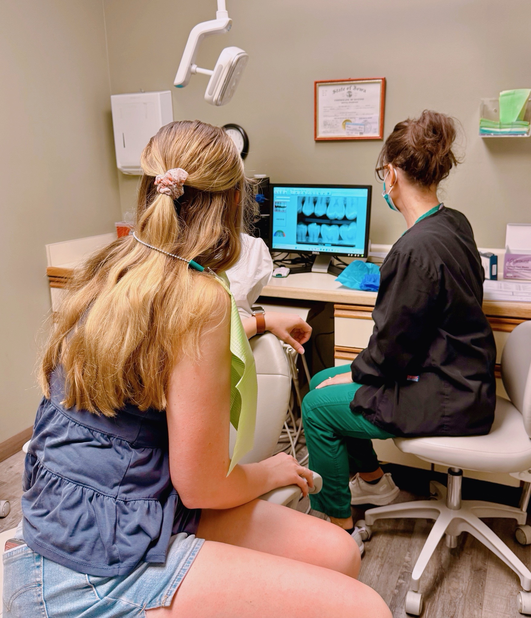 A dentist from Alan B. Evans, DDS, PC in Muscatine, IA points out something on an X-Ray of a patients mouth