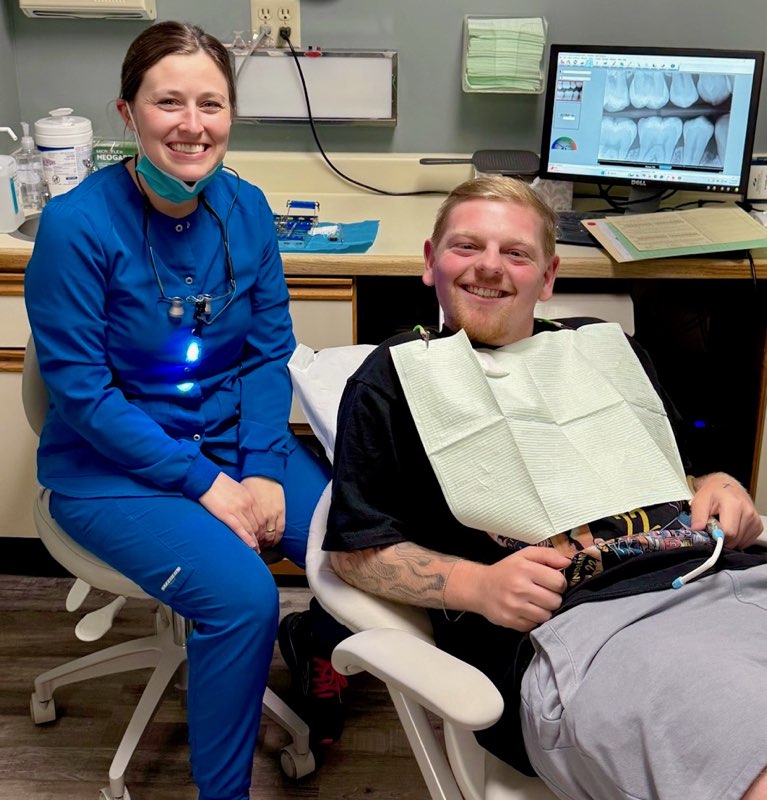 A dentist looks at different x-rays of a patients mouth 